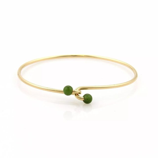 This is an elegant authentic bangle from Tiffany & Co. It is crafted from 14k yellow gold with a polished finish featuring...
