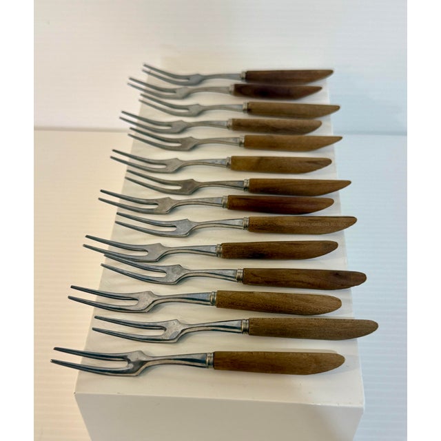A charming set of twelve vintage Japanese cocktail forks featuring sleek stainless steel tines paired with warm wooden...