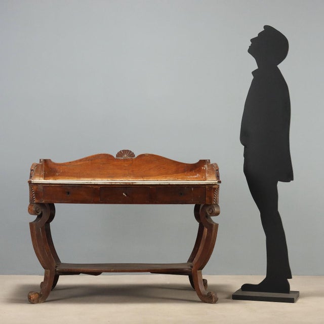 Empire walnut desk dating back to the early 19th century, featuring an elegant and refined structure. The top is made of...