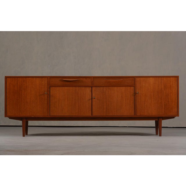 A vintage Danish teak sideboard from Denmark, 1970's. The producer and designer are unknown. Crafted from warm teak wood,...