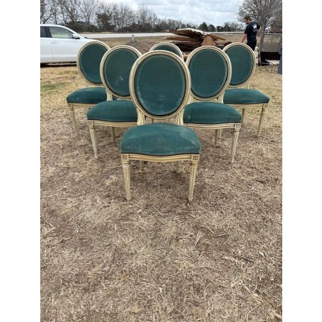 A set of six 19th century Louis XVI-style dining chairs featuring classic oval "medallion" backs, fluted tapered legs, and...