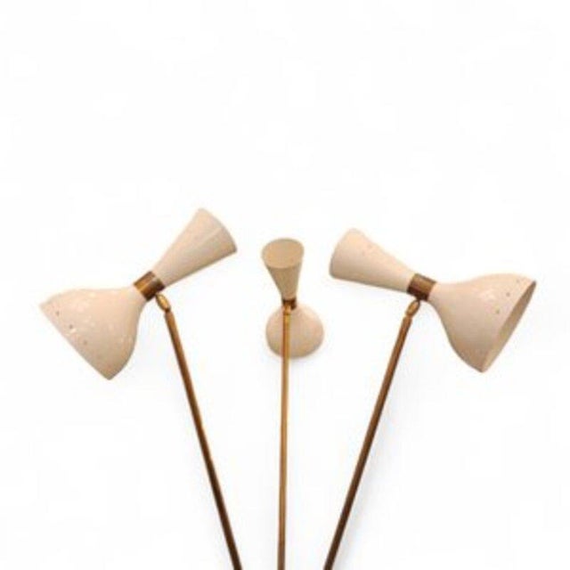 An iconic Italian-designed floor lamp by Stilnovo, pure 1970s style. This tripod lamp features three legs and three arms,...