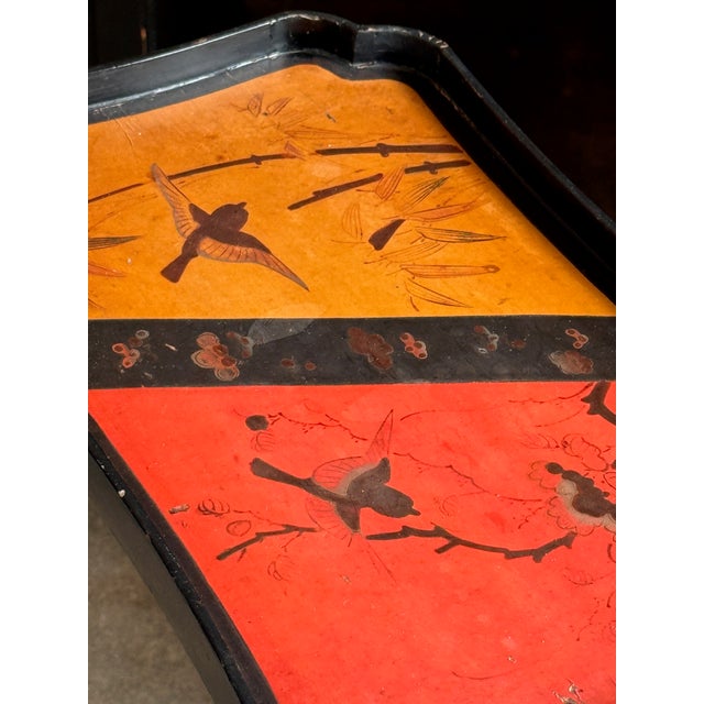 Two tier side table with bamboo frame and lacquered shelves, each tier set with a shaped gallery and decorated in red,...