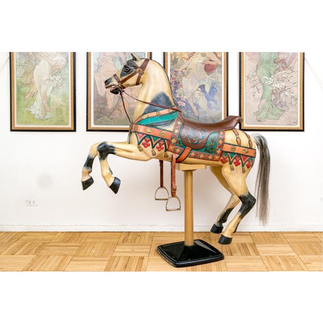 A vintage life-sized mixed-media hand-painted polychromatic carousel horse mounted on a sturdy base looking forward and...
