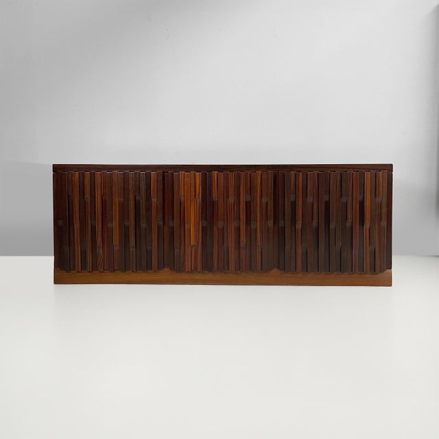 Italian wooden sideboard, 1970s Sideboard in dark wood, featuring a front composed of vertical slats in varying sizes and...