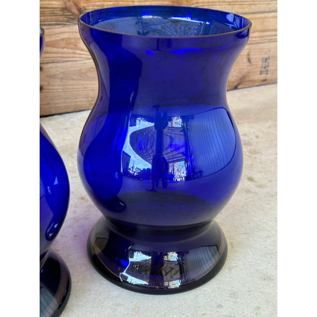 These exquisite vintage cobalt blue vases, crafted from hand-blown glass, showcase a deep, vibrant hue that adds a touch...