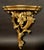 This elegant pair of carved wall brackets is crafted in giltwood and richly ornamented with flowing Rococo-style...