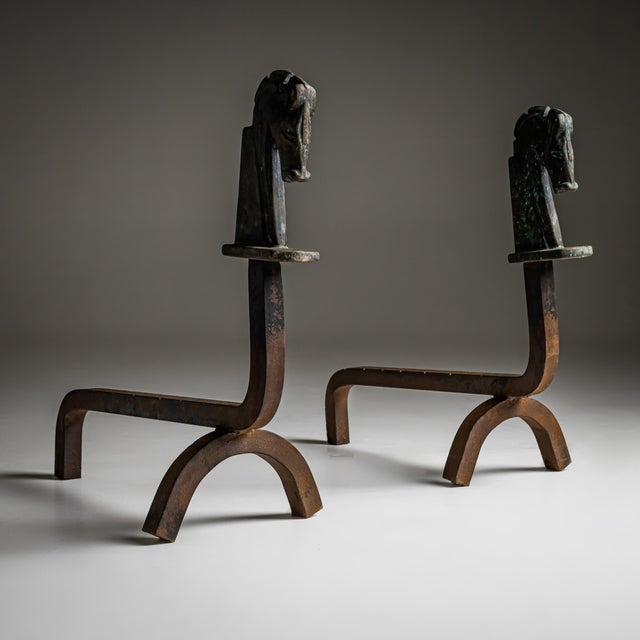 Set of iron andirons featuring stylized horse head finials.