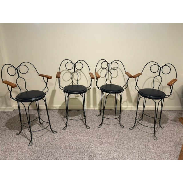 A set of tall barstool height twisted wrought iron ice cream parlor/billiard armchairs featuring circular wire back...