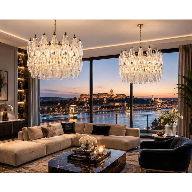 Pair chandelier featuring a circular metal frame with a gold finish, suspended from a matching chain. The light fixture is...