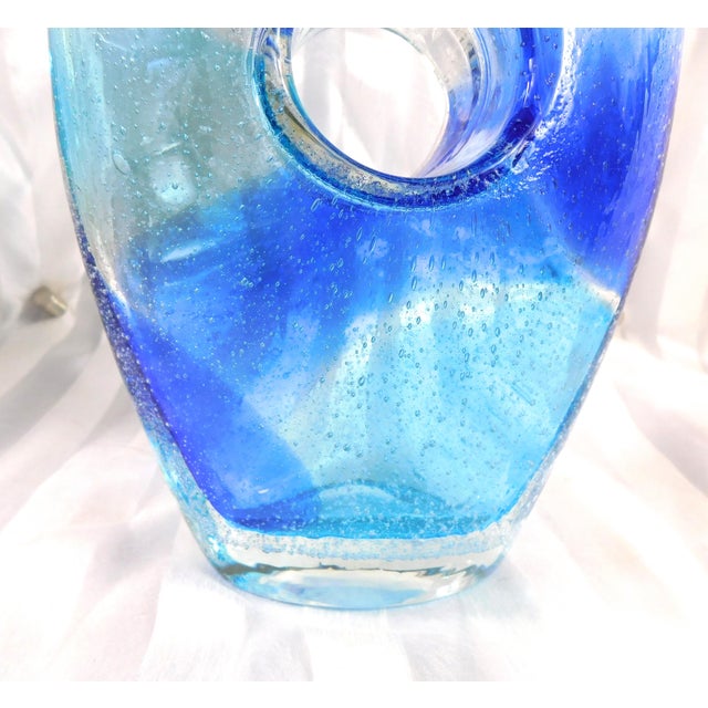 This is a light and dark blue Bullicante art glass vase with a hole in the center. Both sides are shown. One side has a...