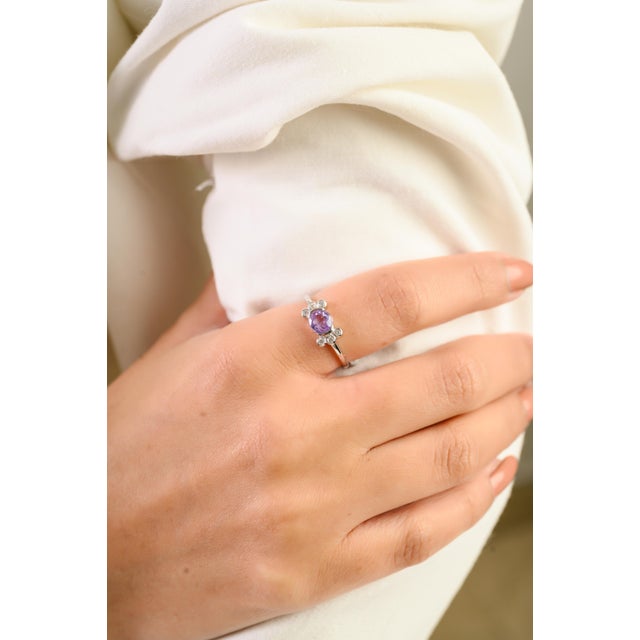 This art deco inspired cluster ring features one oval lavender sapphire totaling 1.11 carats, set in 14K white gold. The...