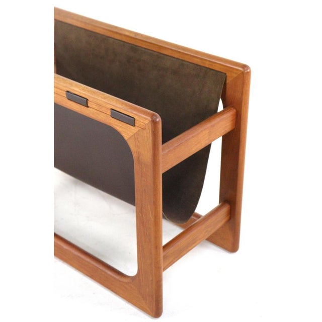 Nice magazine rack with a frame made of solid teak and attractive leather. Cool and typical Danish design with warm...