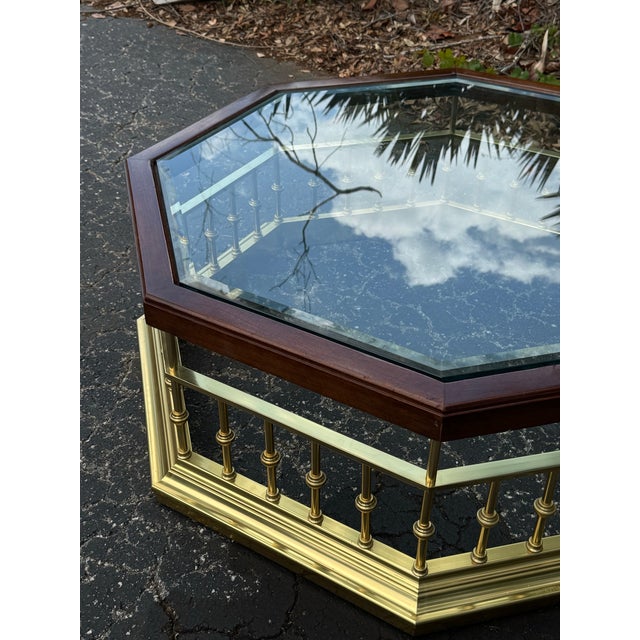 A striking vintage coffee table featuring an elegant combination of solid brass, richly toned wood, and an exceptionally...