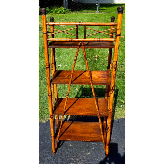 Antique Victorian burnt bamboo etagere featuring four wooden tiers. Design and Materials • Frame: Crafted from...