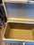 This charming vintage wicker storage trunk features a soft light blue painted finish with a pretty floral rose motif...