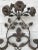 Beautiful and unique, this iron wall sconce is sure to make a statement in your home. Adorned with cast iron rosettes and...