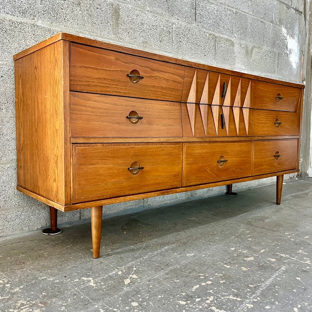 Vintage Mid Century Modern Sculptural Harlekin Style Nine Drawers Dresser. Circa 1960s Features a Harlekin Inspired design...
