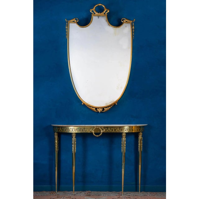 Elegant Italian mid century brass console table with a veneered marble top. Finely chiseled brass decoration.