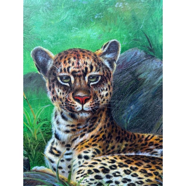 Striking vintage oil on canvas depicting a reclining spotted big cat—likely a leopard or jaguar—set among lush tropical...