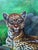 Striking vintage oil on canvas depicting a reclining spotted big cat—likely a leopard or jaguar—set among lush tropical...