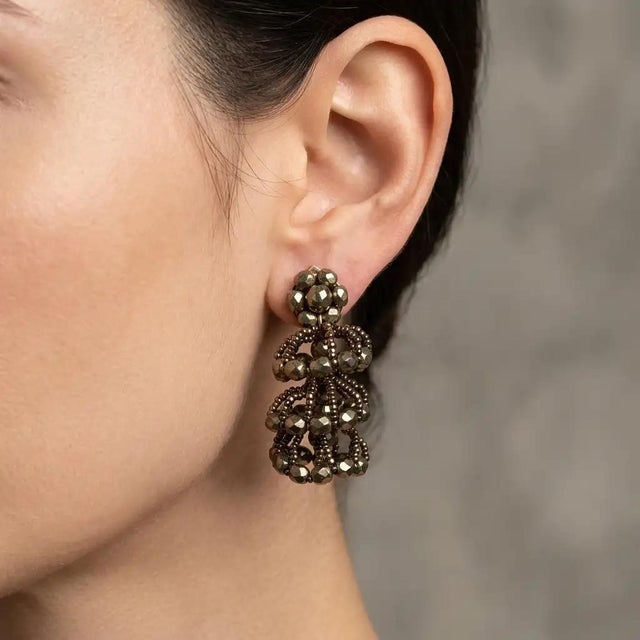 These original 1960s vintage Italian clip-on earrings feature a striking, architectural waterfall design crafted with gold...