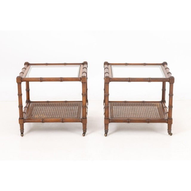 Pair of Regency Style Faux Bamboo Side Tables on Casters, with glass tops and caning. 16.5" H x 18" W x 18" D. Provenance:...
