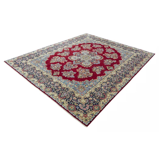 This magnificent Kerman rug impresses with its opulent medallion design, which unfolds on a rich, deep red background. The...