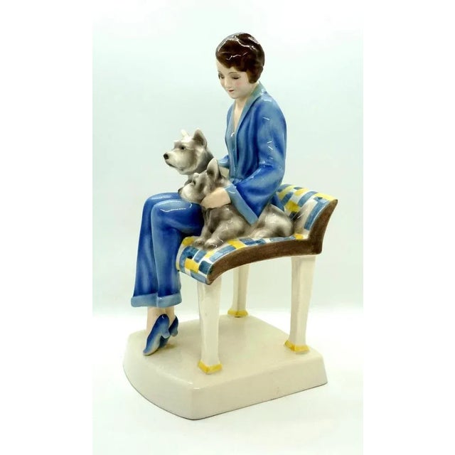 Rarest goldscheider figure group of the 1930s. The young lady in a blue trouser suit with a short brunette hairstyle sits...