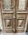Rustic antique wooden entry doors having wrought iron window grates. Lower section of doors has raised pyramid panels and...
