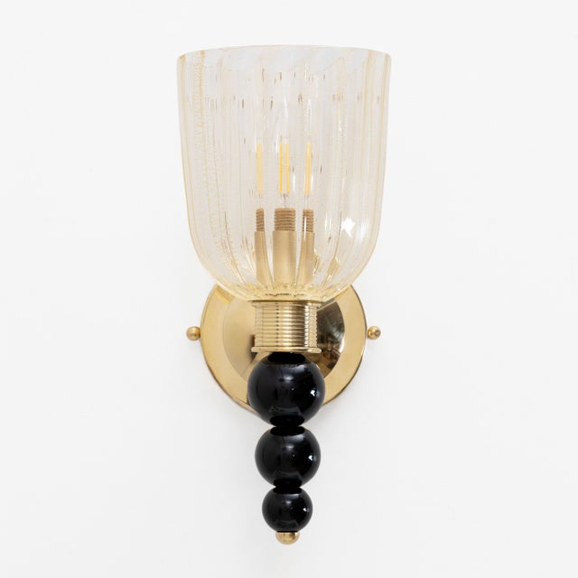 A pair of refined Murano glass wall lamps with gold dust inclusions, made in Italy. The diffuser is made of vertically...