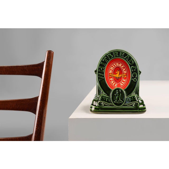 A vintage table lamp from the Whitbreast Pale Ale brewery. In green glazed ceramic with the iconic red Whitbread logo in...