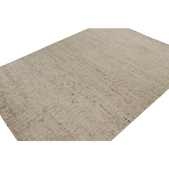 Hand-knotted in wool, this 10x14 modern textural high-pile rug in beige and brown features a simple design, but...