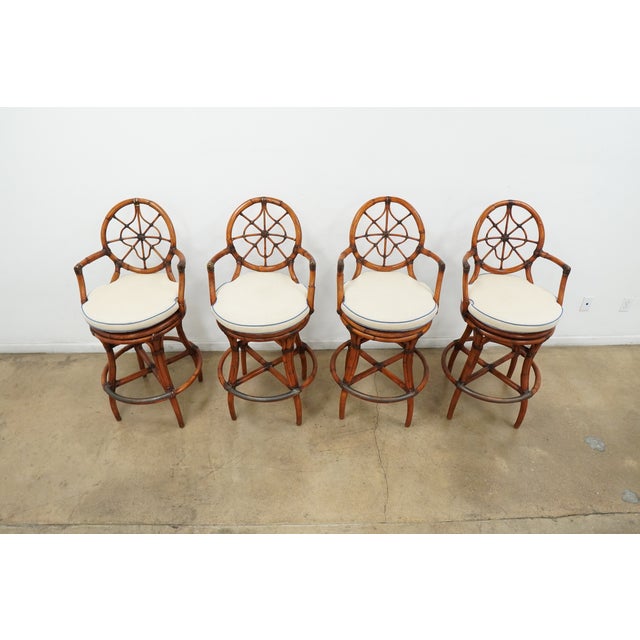 A charming set of four vintage faux bamboo swivel bar stools dating to the late 1970s to 1980s, featuring circular...