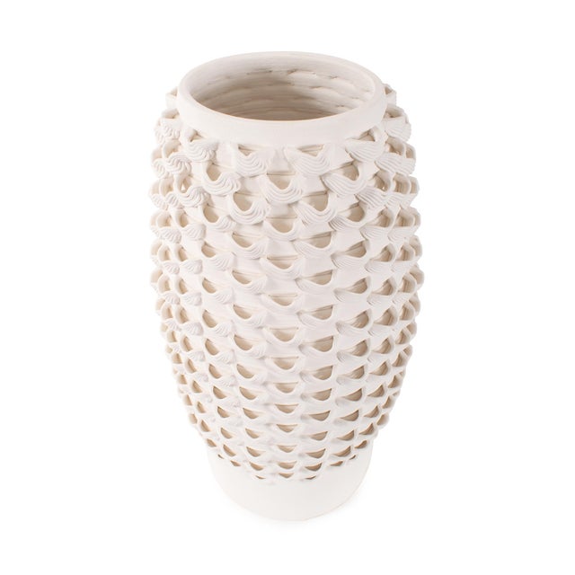 Featuring a rhythmic pattern of intricately layered, hand-applied loops, this all-white design creates visual interest...