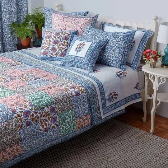 The Aizel Patchwork Quilt features a patchwork assortment of soft, yet vibrant hand block printed floral designs in blues,...