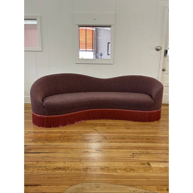Glamorous curved sofa custom upholstered in pink & navy Maharam Gale fabric in color Diorite. Base is bordered in fine...