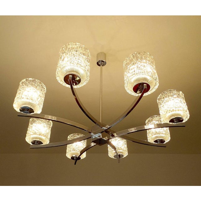 Large Vintage 1970s Kaiser Pendant Light, featuring an unusual design with eight intertwined curved chrome spokes,...