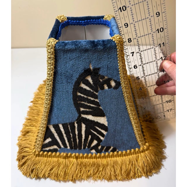 Striking custom lamp shade crafted from Finesse Regal zebra velvet fabric in rich sapphire blue, featuring bold black and...