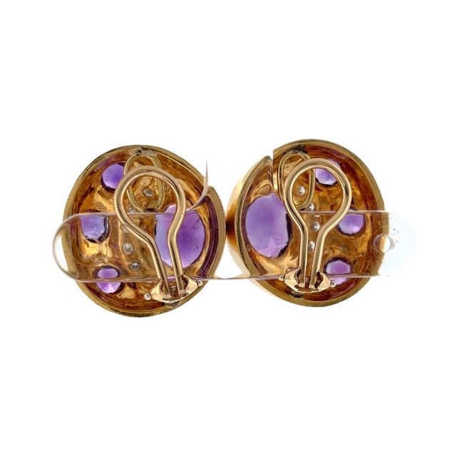 Vintage 18K yellow gold clip-on earrings featuring a round design set with round and oval cut amethysts accented by a...