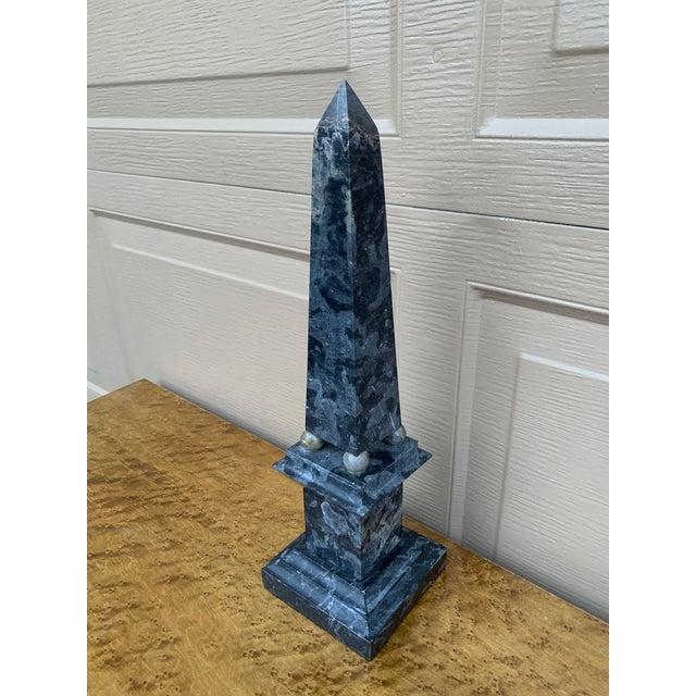A beautifully proportioned marble obelisk in richly veined shades of blue and cream. The sculptural silhouette and...