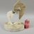 20th C organic modern Travertine stone sculpture of a mother dolphin her baby dolphins holding a ball. The base is in the...