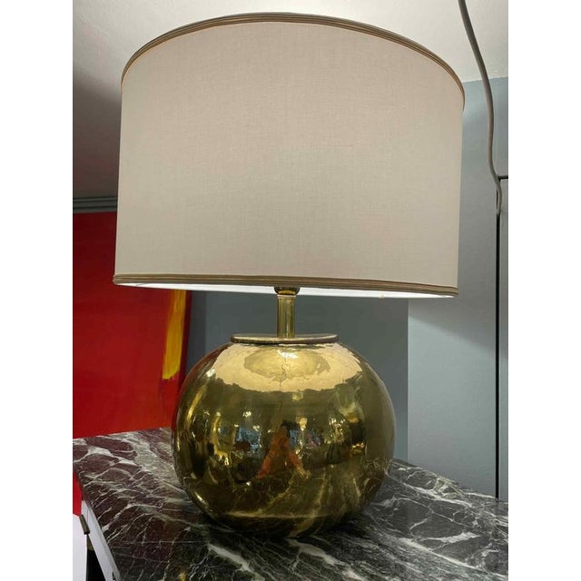 Table lamp with a spherical hammered brass base and a newly crafted lampshade. The lamp is in perfect condition and is...