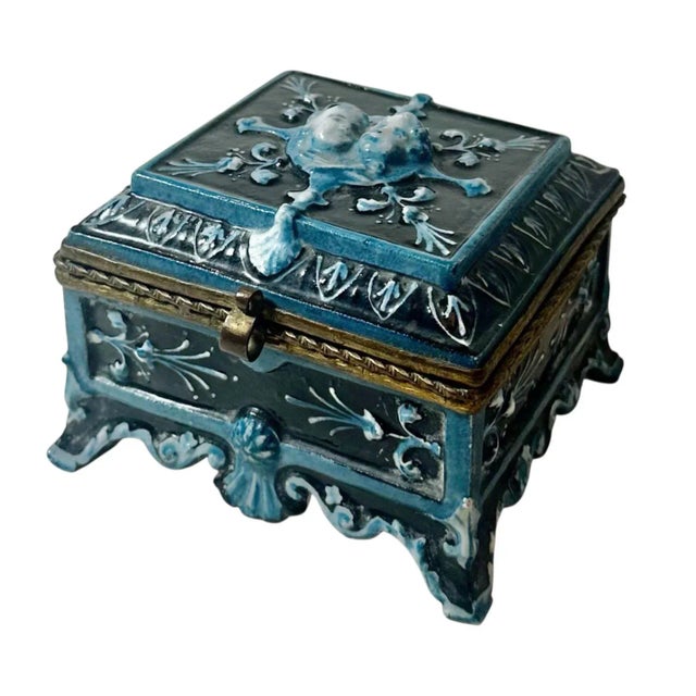 A stunning French majolica trinket box dating to the 1890s, featuring two beautifully modeled cherub heads at the top in...