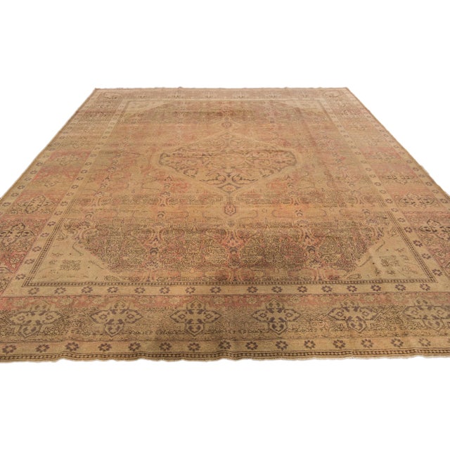 Beautiful antique Tabriz hand-knotted wool rug with the tan field. This Persian piece has a rusted designed frame and...