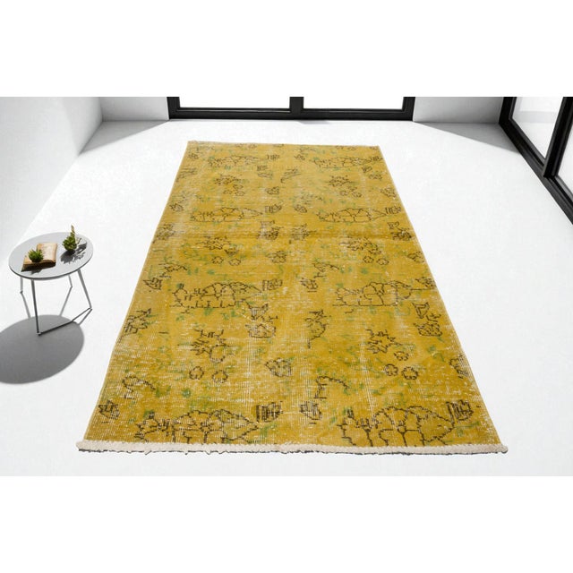 This is a vintage Turkish Oushak rug from the Mid 20th Century. The piece was hand-knotted.