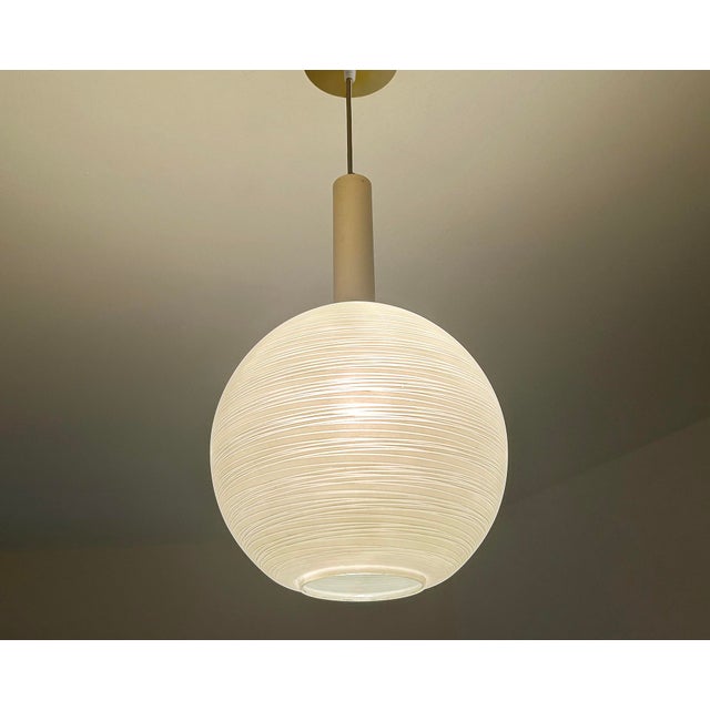 Mid century pendant light featuring a pastel green glass globe shade with whirlwind pinstriped pattern, brass glass cap,...