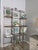 Antique French iron and brass boulangerie baker’s rack featuring decorative scrollwork, brass elements, and beautifully...