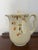 A classic Hall China covered coffee pot in the beloved Jewel Tea Autumn Leaf pattern, featuring a warm ivory glaze...