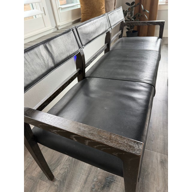 Ben Soleimani “Benton” bench in black leather and dark cerused oak, featuring a beautifully architectural silhouette with...